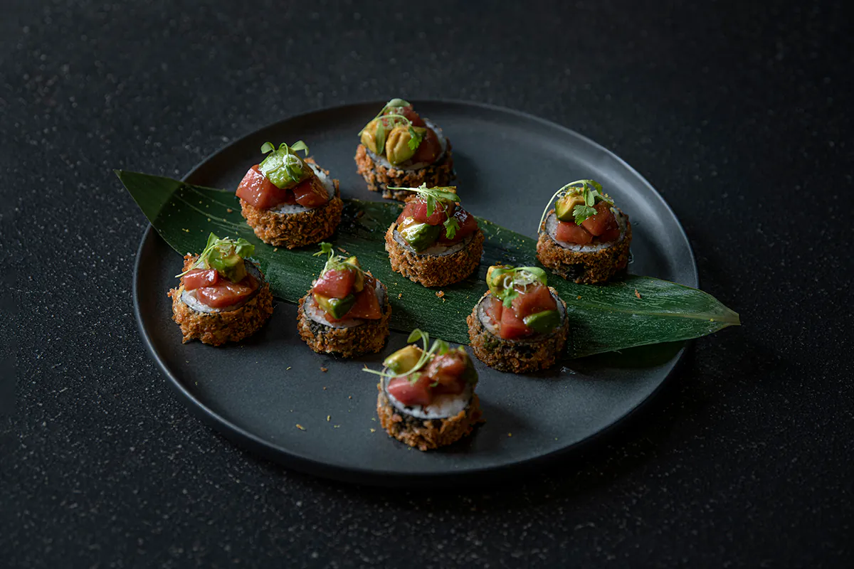 Crunchy sushi rolls topped with tuna and avocado, on a dark plate at Shiki Sushi，a Japanese Restaurant in Santa Rosa