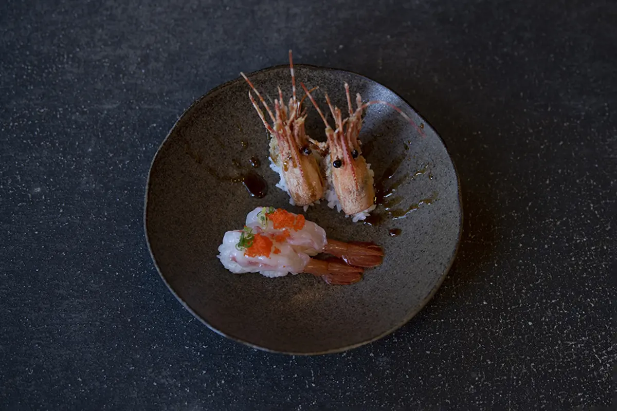 Grilled and raw shrimp sushi on a dark plate, topped with caviar at Shiki Sushi，a Japanese Restaurant in Santa Rosa